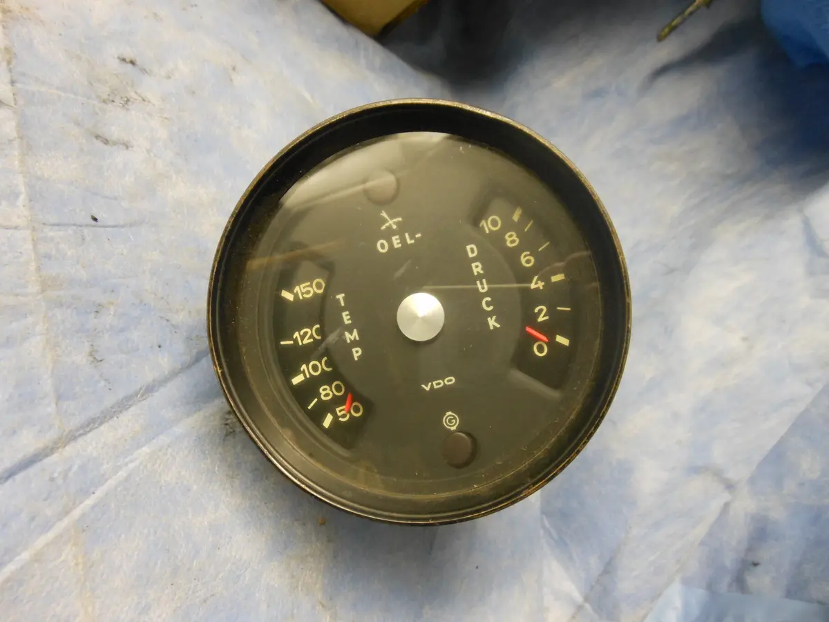911E/S Oil Temperature Pressure Gauge Silver Button In Middle, Says: Temp Druck Oel G On Bottom 
Has Numnerical Scales
Euro Temp (50-150), Oel Light And Druck (0-10) W 1 Generator Light Early 1970 Gauge - 911.641.103.00 1